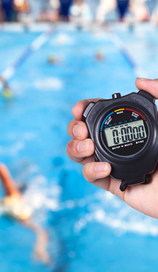 Chronometer in de hand boven het zwembad