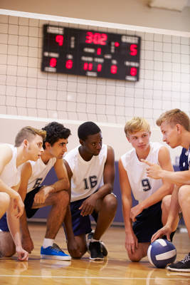 geef tieners een stem
5 jongeren overleggen gehurkt op volleybalveld indoor