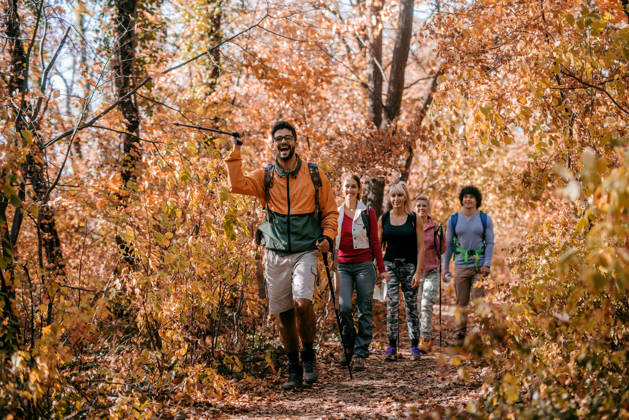 Groep wandelaars in bos tijdens de herfst.