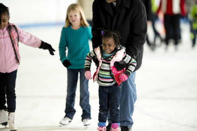 Group of people skating on an ice rink.