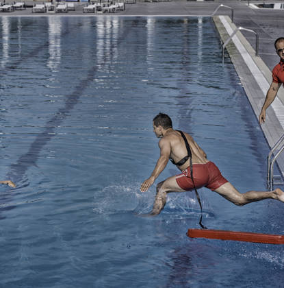 Man springt in zwembad om drenkeling te redden tijdens cursus redder cursus 