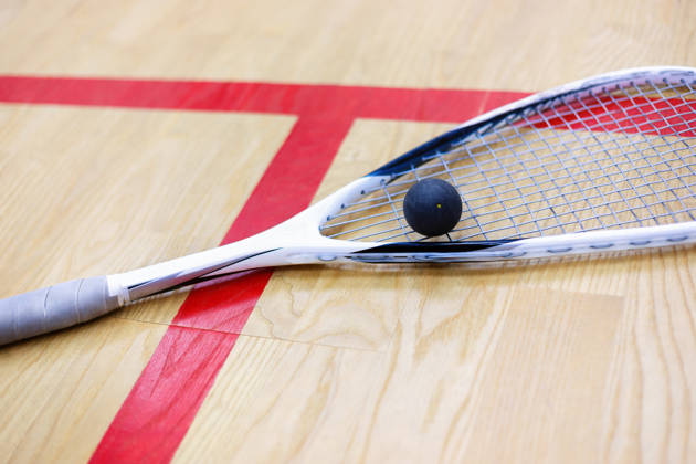 Squashracket met balletje op squashvloer