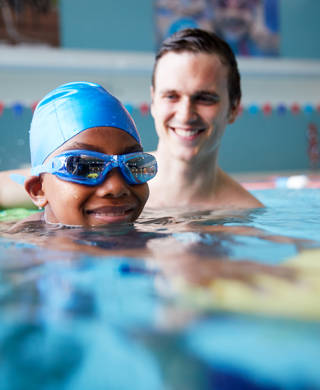 Mannelijke zwemcoach geeft les aan jongen