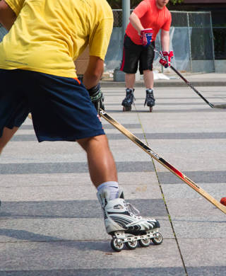 Washington DC, USA - August 15, 2015: Young men play roller in-line hockey outdoor in downtown.
