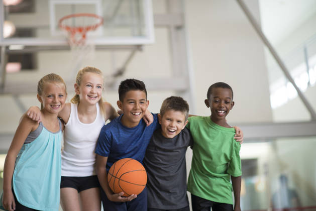 Multi culturele groep jonge kinderen met basketbal