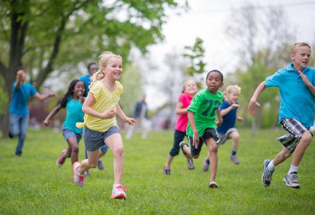 Groepje kinderen loopt op grasveld