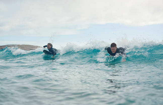 Shot of a young couple out surfing together at the beach