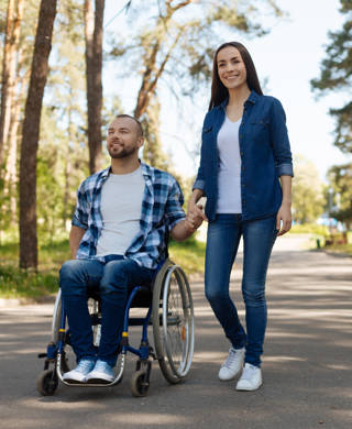 Vrouw en man in rolstoel in bos