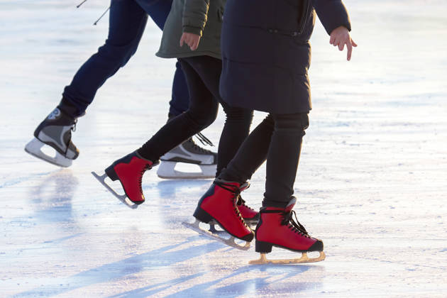 different people are actively skating on an ice rink. hobbies and leisure. winter sports