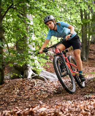 Young woman with mountain bike on Italian mountains: Downhill in the forest