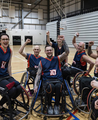 Team of wheelchair users playing basketball in the North East of England. They are wearing sports jerseys, competing against one another.