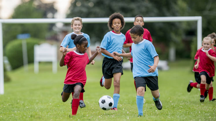 Multiculturele groep kinderen voetballen samen